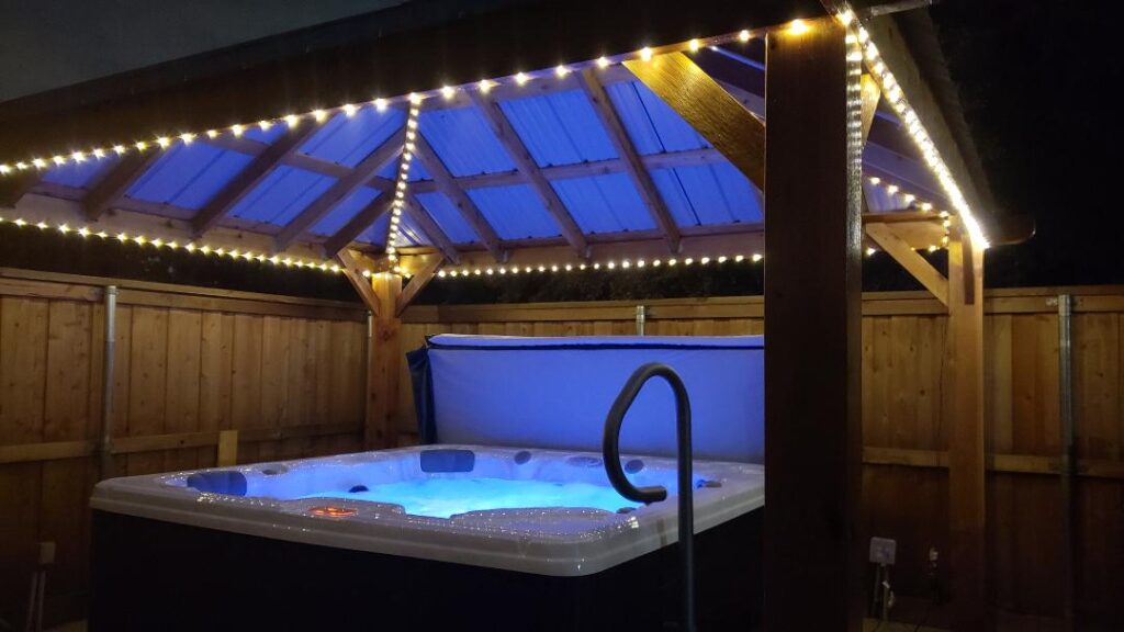 5 Reasons a Hot Tub is the Perfect Way to End Your Day 8 Hot tub with lights under a lighted gazebo in a nighttime setting.