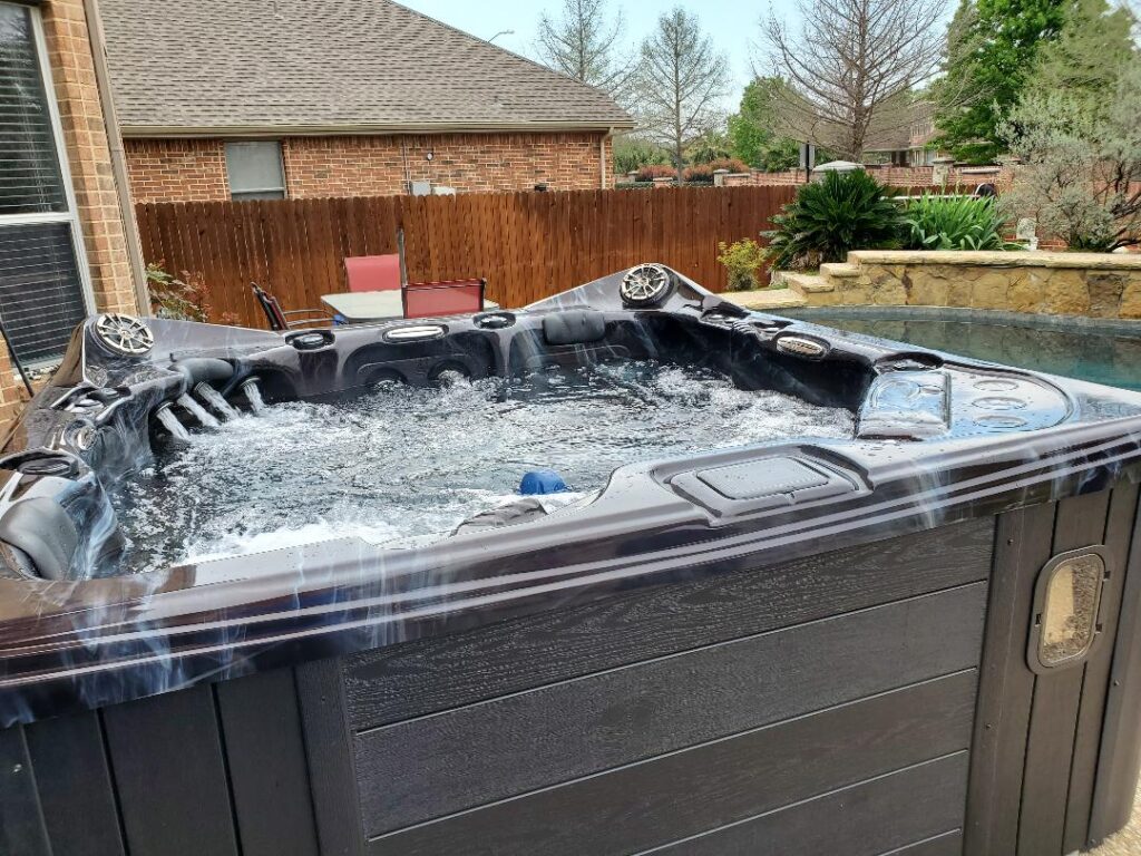 How to Deep Clean Your Hot Tub 5 A hot tub in a backyard with the jets on.