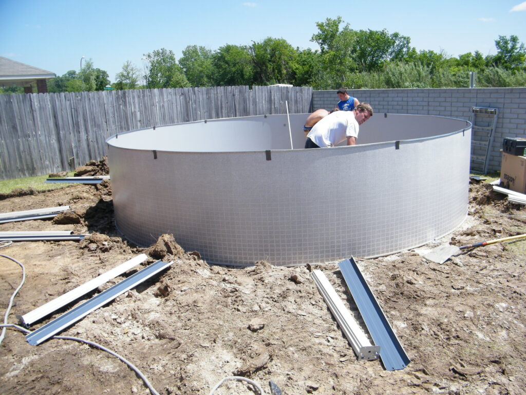 8 Best Tips and Tricks for Setting Up an Above Ground Pool 4 A group of three men setting up an above ground pool.