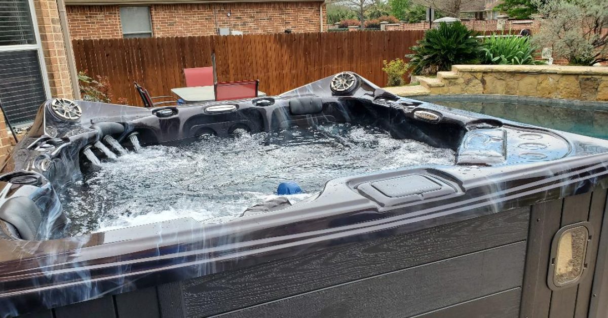A hot tub in a backyard with the jets on.